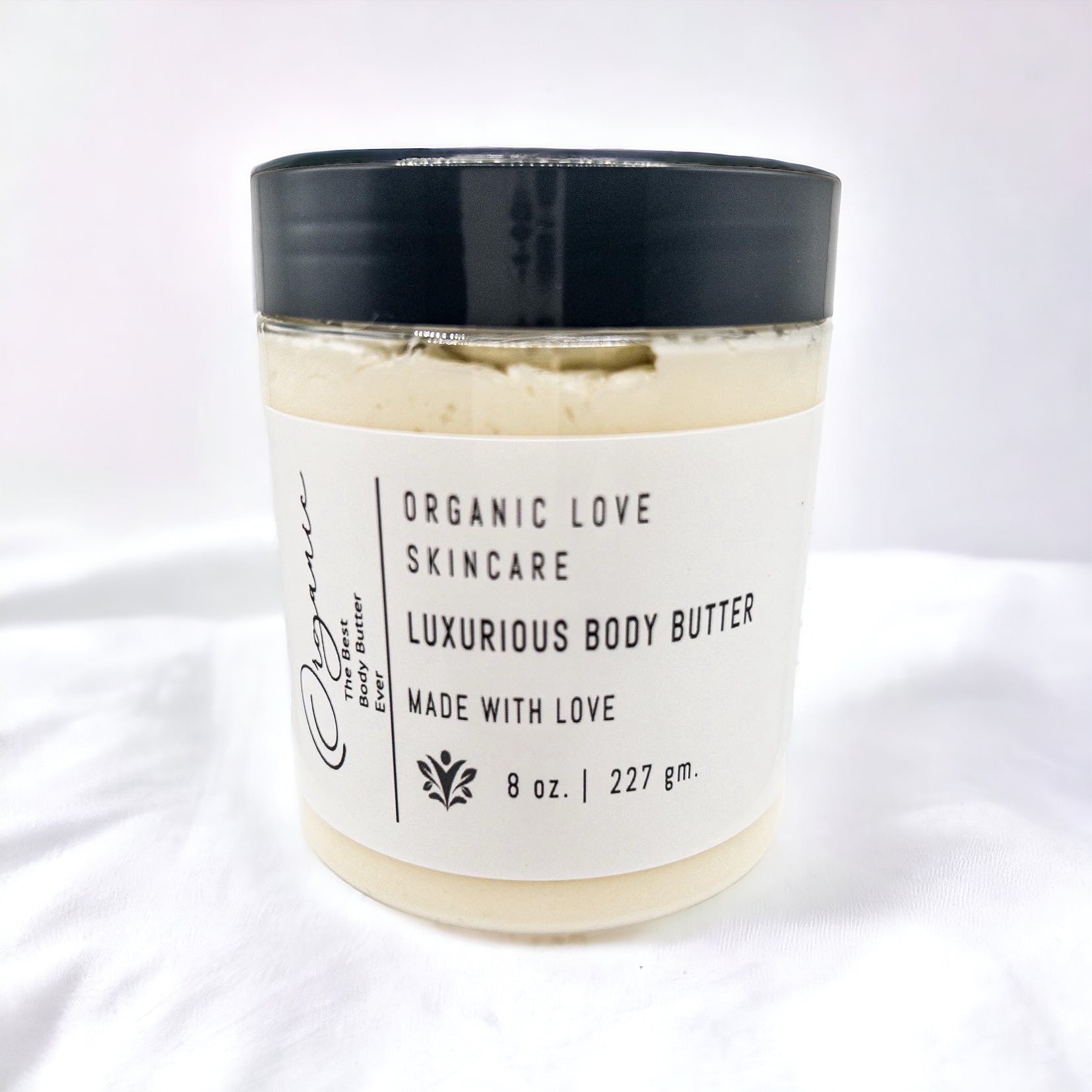 Jar of luxurious body butter with a black lid on a white background