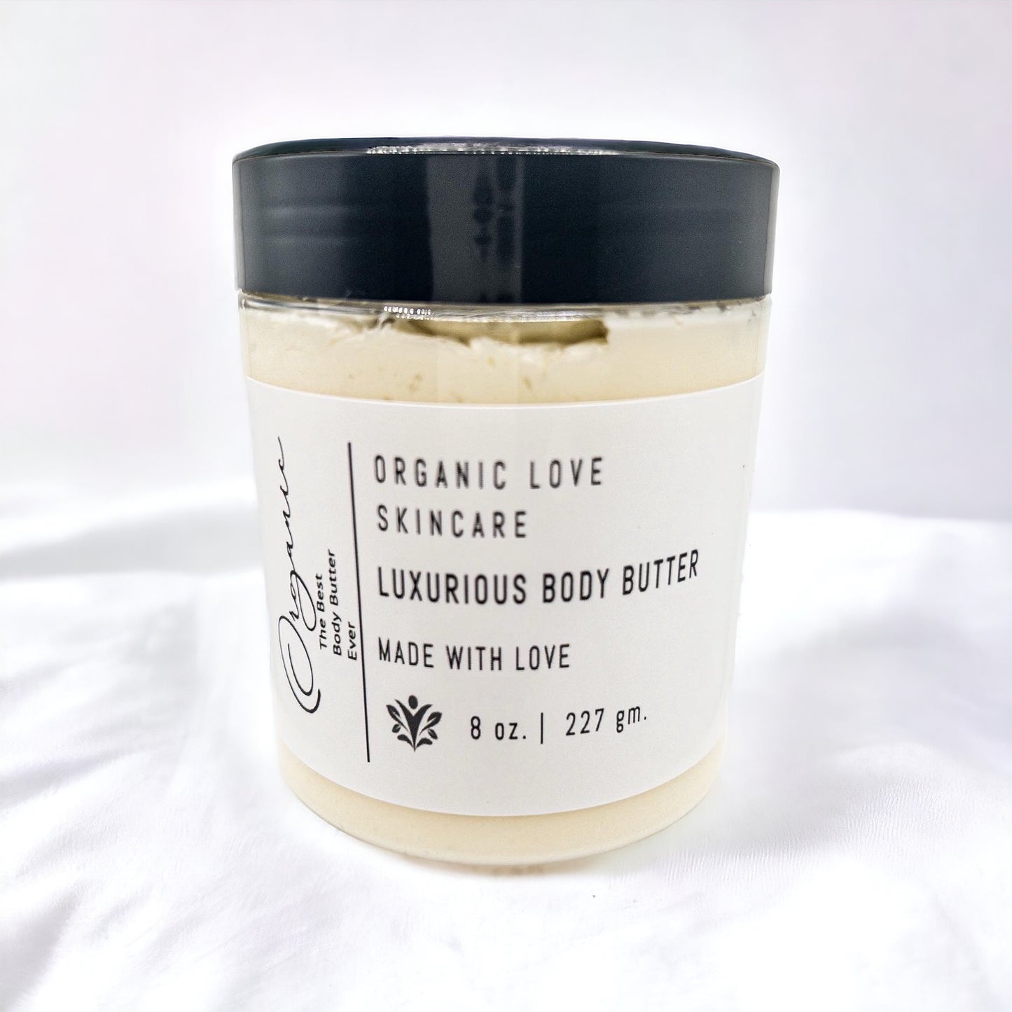 Jar of luxurious body butter with a black lid on a white background